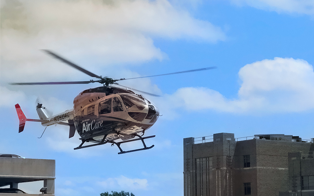 medical helicopter flying over a building