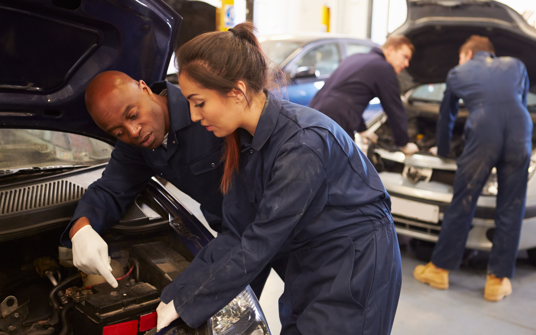 Teacher and student working on a car