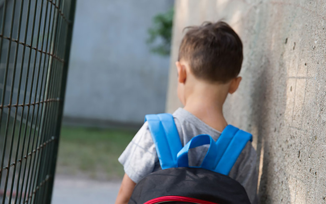 2018 june chronic absenteeism policy brief thumbnail: a school child carrying a backpack with his back towards the camera