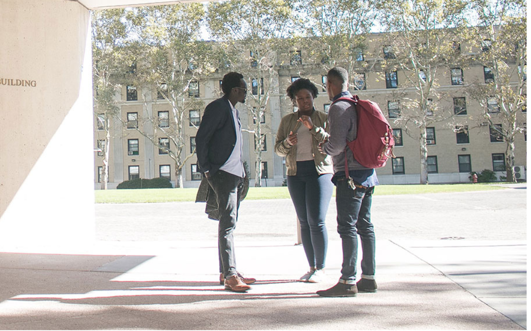 3 people talking at what looks like a university
