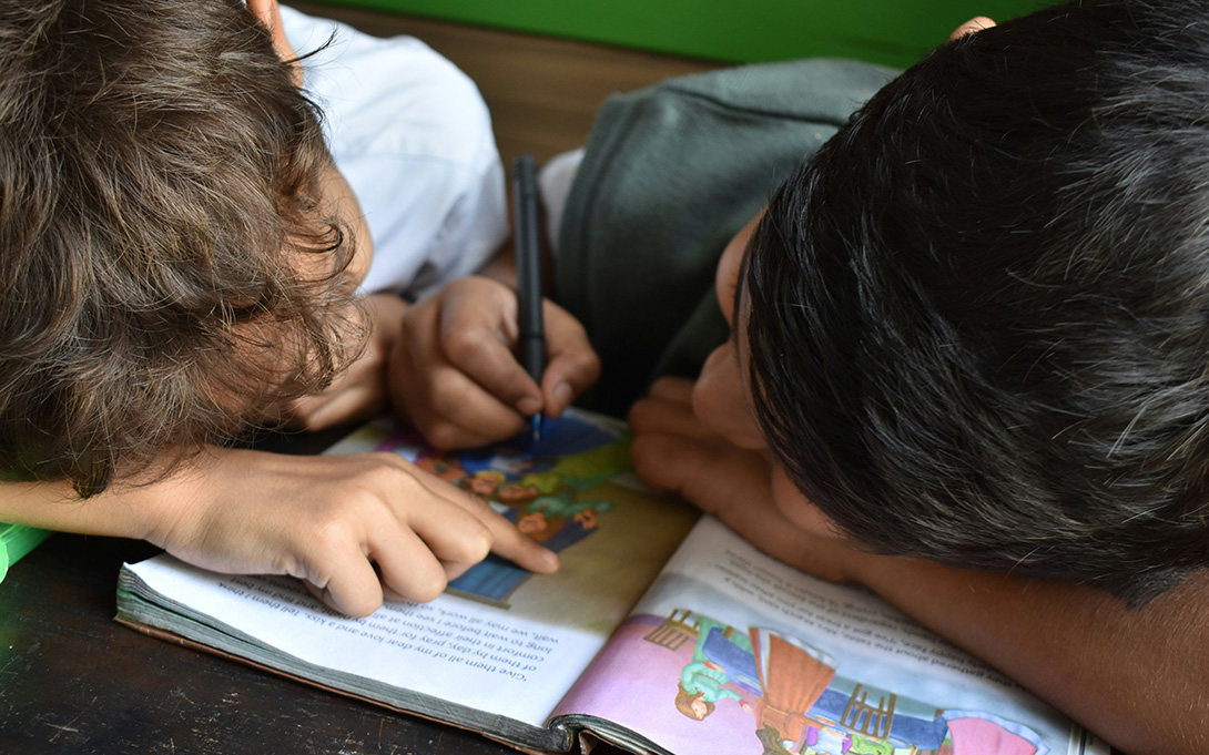 two young children reading a picture book together