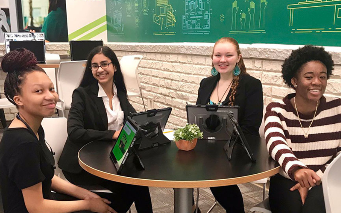 4 students at a table with computers