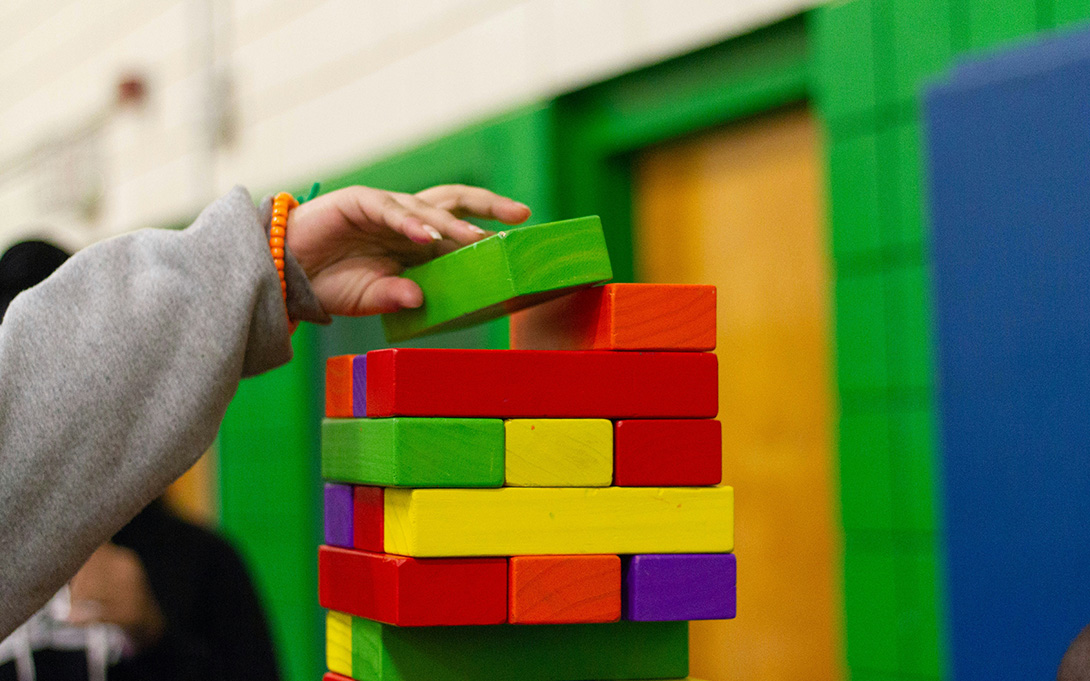 a child's hand building with blocks