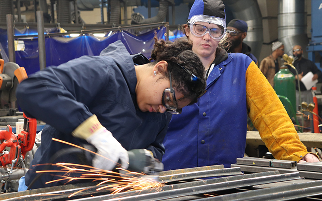 Two students learning welding technique in CTE class