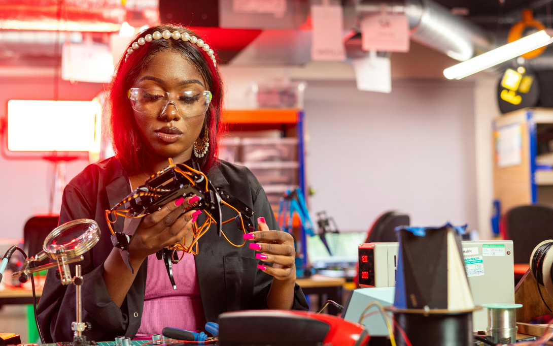 Student with safety goggles in a lab with a machine or tool