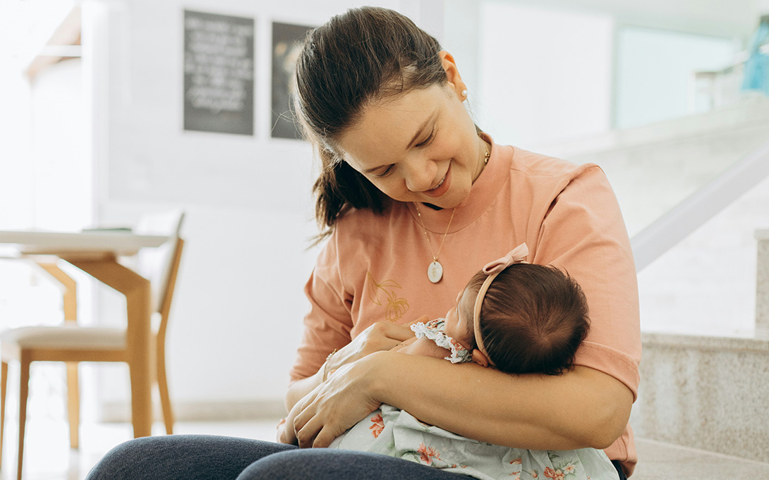 a young mother holding her infant child at home