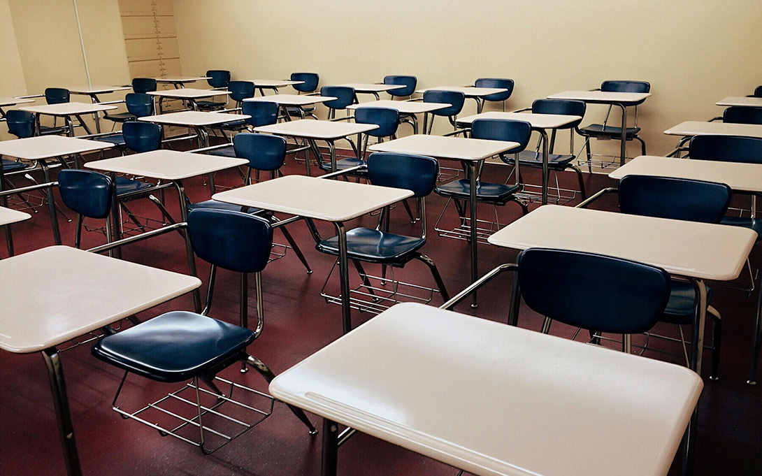 An empty classroom with desks and chairs