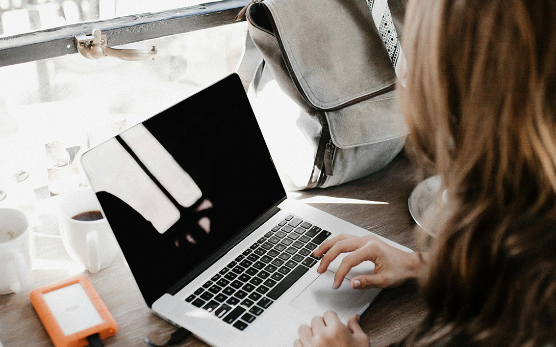 cover photo of reconnect 2025 report: a young female checking information on a laptop