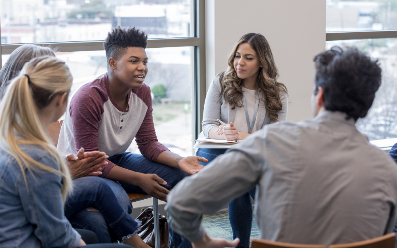High school students sitting in chairs in a discussion