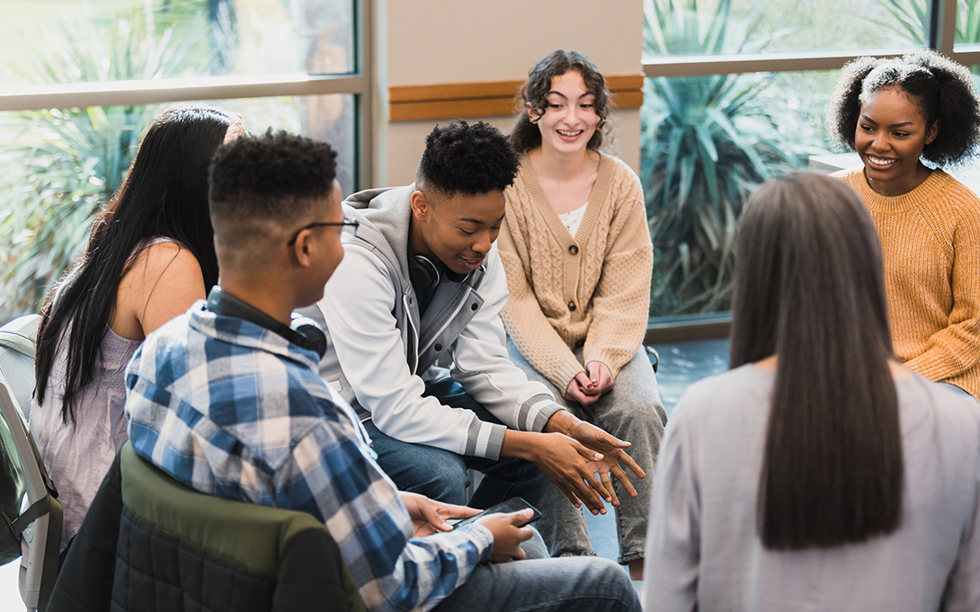 Stock photo of a group of high school students talking in counseling session