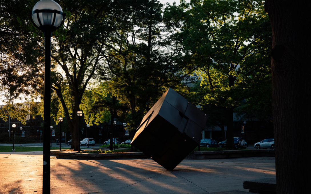 	The Cube in Regents Plaza in the warm glow of a sunset on campus.