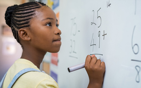 a student calculating additions on whiteboard