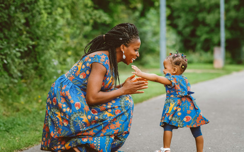 A toddler runs towards her mother.
