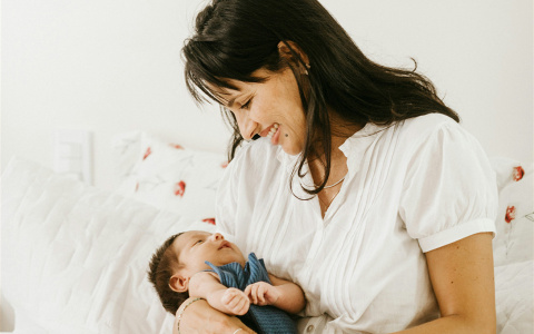 a mother holding an infant in her arms and smiling